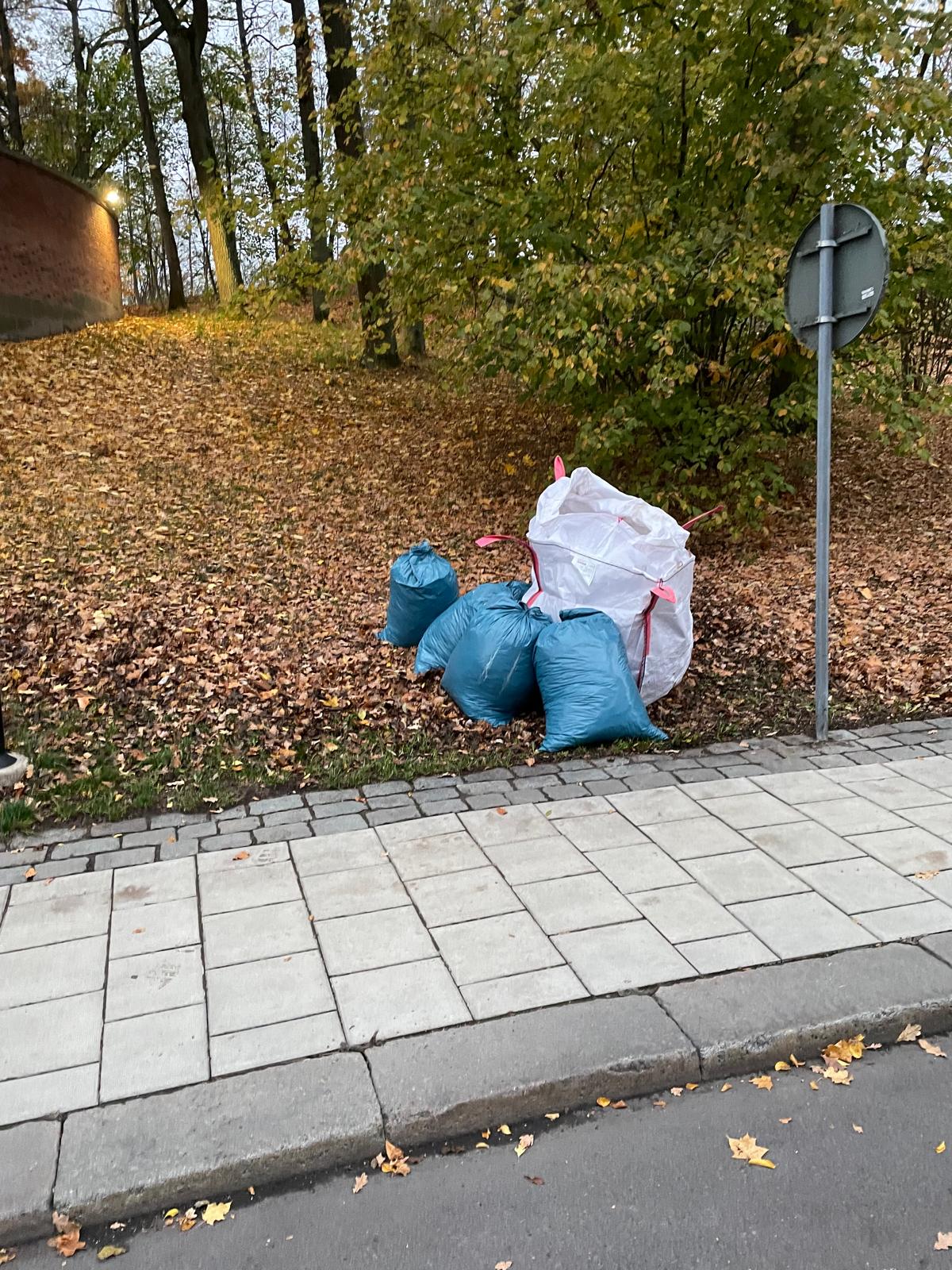 Säckar med byggavfall på trottoar.